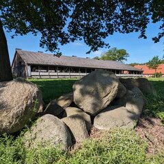 Feldstein mit einer Stallung im Hintergrund